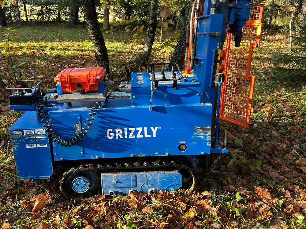 Foreuse géotechnique sur chenilles d’Experts Sols, sur un terrain arboré